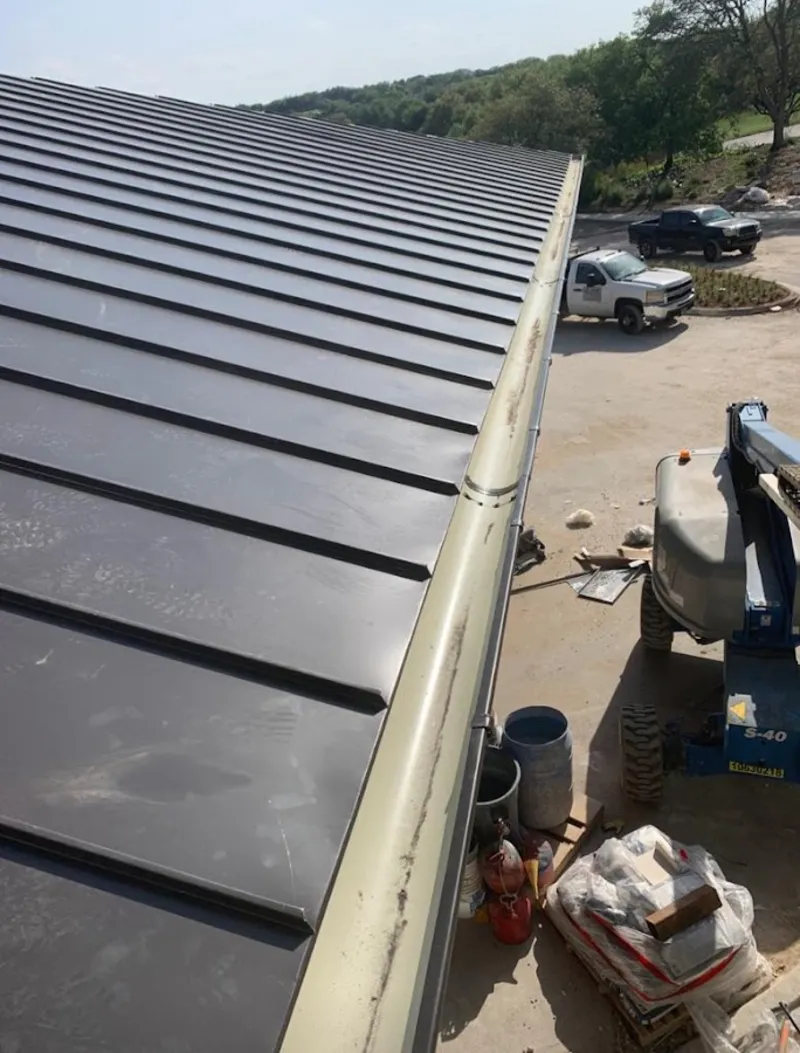 Standing seam panel and gutter detail on a metal roofing jobsite in Walnut Ridge